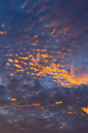 Beautiful golden cloud in a blue sky just before sunset. Scenic sundown cloudscape for background. Dramatic sunset cloudscape. Meteorology, heaven, peace, picturesque panoramic sceneryの写真素材