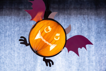 Halloween pumpkin lamp hung in dark room. Symbol of Halloween, indoor decorations. Halloween pumpkin head jack lantern.Round lamp shape of pumpkin used to decorateの写真素材