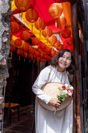 Asian woman wearing Vietnamese culture traditional dress enjoys sightseeing at Heritage Village in...