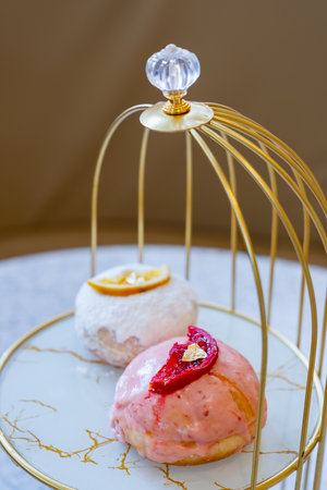 Filled donuts with orange and strawberry toppings and a gold leaf on top. Strawberry Cake Glazed...