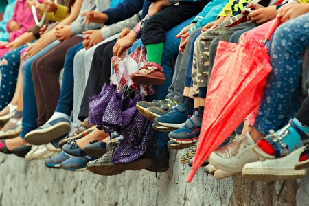 Childrens feet. Bottom view. Spectators of a theatrical performance in the open airの写真素材