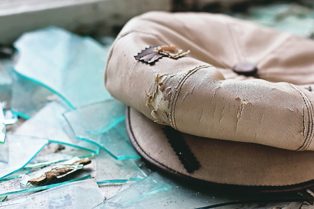 Old ragged female headdress: hat or beret on broken glass.  Concept of accident or poverty...