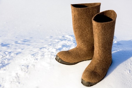 Warm Russian village felt boots of felt with a rubber sole are standing on a snow drift.の写真素材