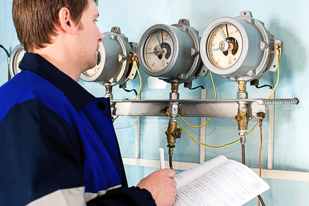 Engineer, worker registers readings of sensors and pressure gauges.