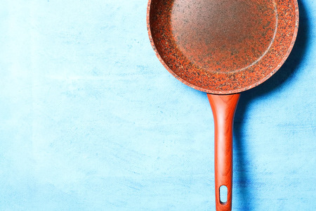 Frying pan with granite coating on blue background. Copy space. Top viewの写真素材