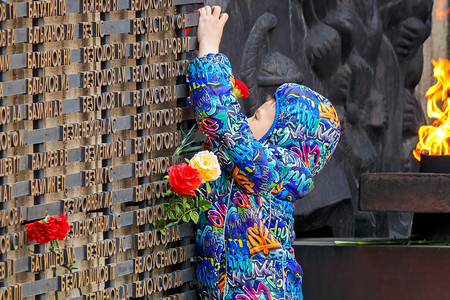 Barnaul, Russia, May 9, 2018: a little boy lays flowers at the memorial of glory at the eternal flame. The memory of the fallen soldiers in the great Patriotic war.のeditorial素材