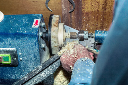 Work on a lathe on a tree. Close-up of male hands during the processing of wooden blanks