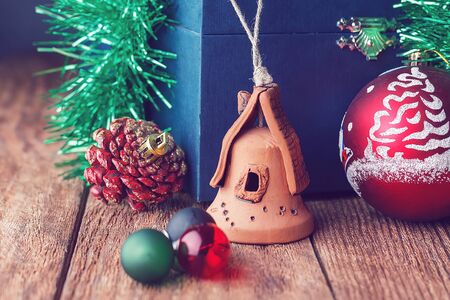 Christmas toys on the wooden texture floor close-up. Balls, toy house, fir cone and chest. Attributes Of Christmas.の写真素材