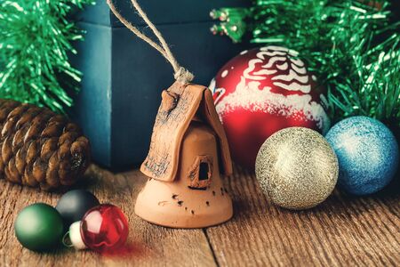 Christmas toys on the wooden texture floor close-up. Balls, toy house, fir cone and chest. Attributes Of Christmas.の写真素材