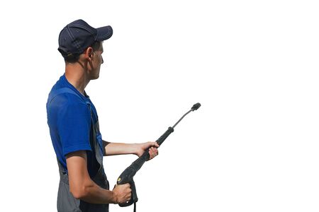 car wash worker in overalls with a gun for washing on a white background while working. Isolateの写真素材