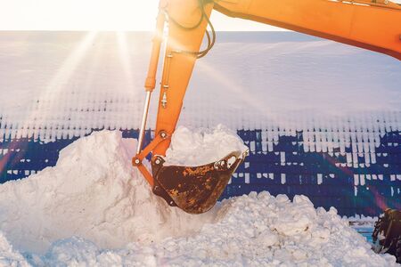 Excavator bucket with snow. Cleaning and removal of snow in winter.の写真素材