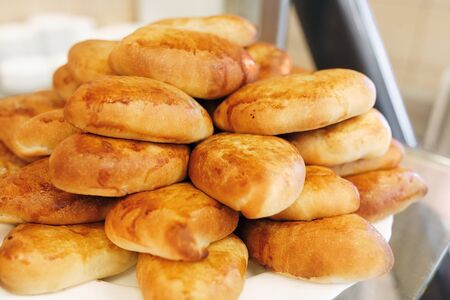 Fresh pastry. A lot of browned pies are on a platter in the dining room