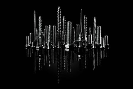 Advertising photo for products. Self-cutters and screws are built in the shape of a city on a black background. Consumable mate rial for construction. A megacity or a city with high-rises of self-cutters. Small self-tapping screws and mounting screwsの写真素材