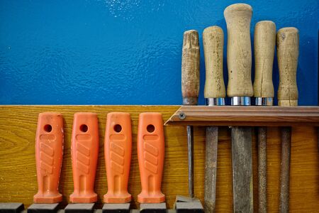The carpenter's tools hang neatly on the wall. Workplace order. Rashpil, file and chisel close-up. Copy space.の写真素材