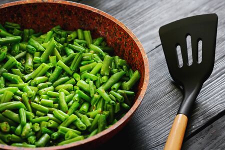 Vegetarian food. Fried string beans in a pan. Stylish background for design. Minimalism. Healthy food from vegetablesの写真素材