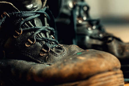 Old worn work boots with lacing. Leather shoes that require repair or replacement. Closeupの写真素材