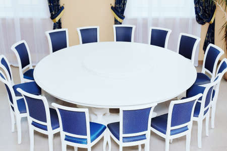 Empty white round conference table and chairs. Resolving conflicts and problems through diplomatic means.の写真素材
