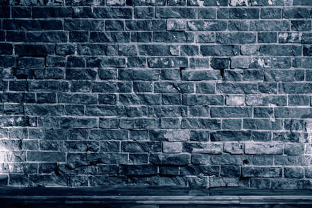 Solid brick wall with rough old masonry. Dark abstract background for the design. Part of the old buildingの写真素材