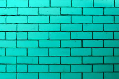 The brick wall is turquoise or green. Empty and clean surface with brickwork. Background blank for...