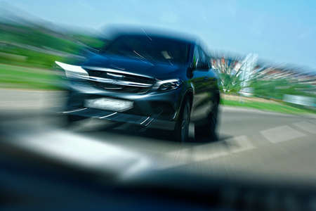 Black car in traffic on the highway. Emergency situation and the possibility of a high-speed collision. Violation of rules on the road.の写真素材