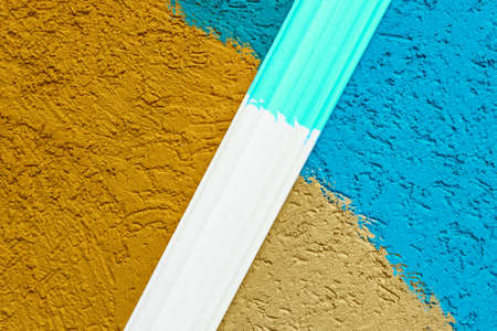 Rough plaster surface painted in a bright color. Variations of harmony and color compatibility in the repair. A sample of paint mixing on the wall with space for copying. Abstract background for the design.の写真素材
