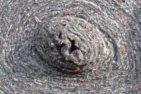 Rolls of factory textiles close-up. Raw material or material for making rags. Background with space...