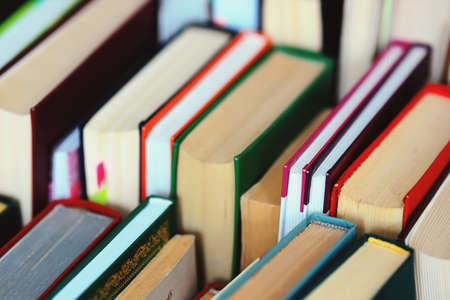 This is a lot of books standing together in several rows. Solid background of books in close-up.