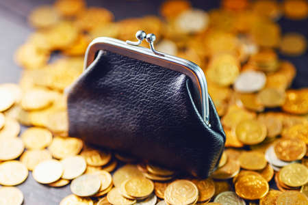An old black wallet sits on top of a pile of yellow Russian coins. The concept of inflation and poverty. Pension reform. Investment of money.の写真素材