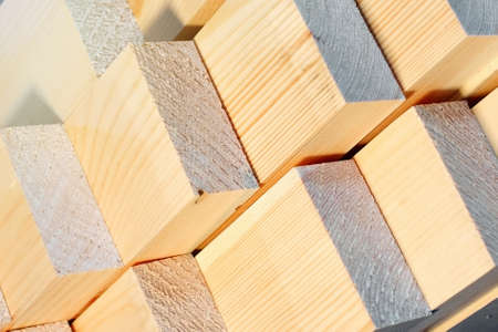 These are the ends of the planed wooden bars at the sawmill or in the carpenters workshop. Sawing drying and marketing of wood. Industrial backgroundの写真素材