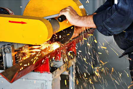 Metal sawing in the workshop at the production site with a stationary machine. Electric circular saw...