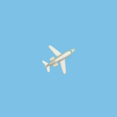 The plane on a blue background. Concept of air travel or travel. A look from above. A small toy...