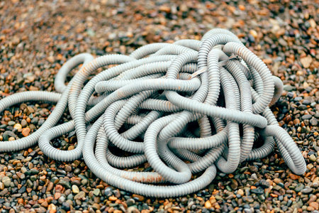 Plastic corrugated hose for insulation of wires lies on the crushed stone. Backgroundの写真素材