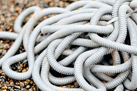 Plastic corrugated hose for insulation of wires lies on the crushed stone. Backgroundの写真素材