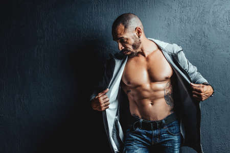 A brutal middle-aged man opened a sports jacket. Muscular body and cubes of the press on the...