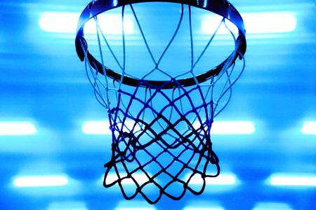Basketball hoop against background of bright spotlights on ceiling. Bottom view. Sporty back. Blue Neon color.の写真素材