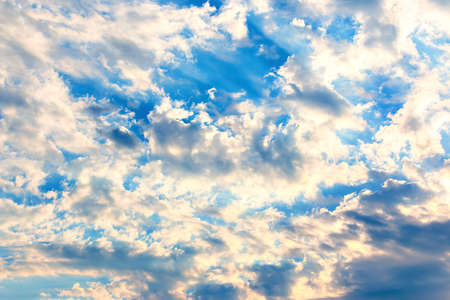 Dramatic sky with feather clouds. Suns rays shine through clouds. Colorful background.