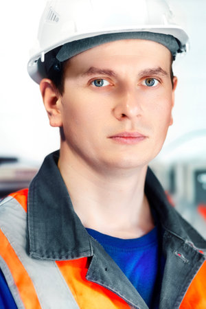 Portrait of young Caucasian engineer in white helmet and protective vest. Gas industry worker at production facility.Real scene.の写真素材