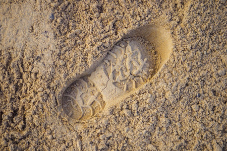 Single male footprint. Footprint from shoe or spade in sand. Background..