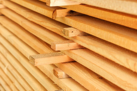 Wooden boards are stacked in a sawmill or carpentry shop. Sawing drying and marketing of wood. industrial background.の写真素材