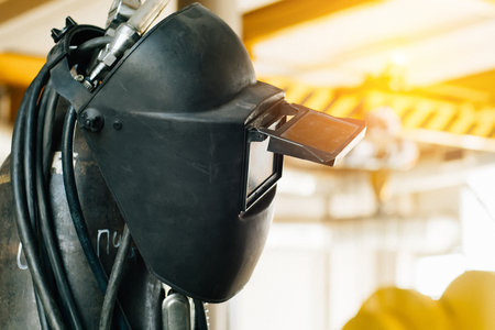 Welders protective mask hangs on oxygen cylinder in production hall. Industrial background..の写真素材