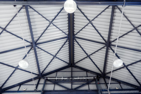 Roof of industrial hangar or warehouse with metal ceiling and lighting lamps. Inside view..の写真素材