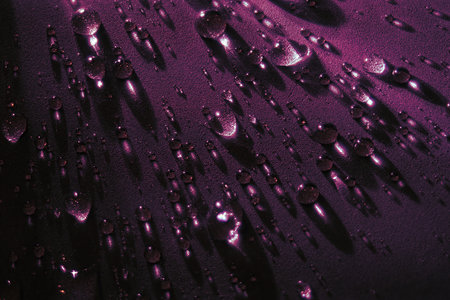 Round drops of water on dark background. Through transparent drops of water pass rays of light. View from top. Beautiful back for screensaver. Abstract background..の写真素材