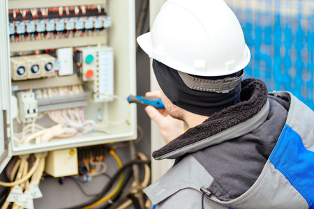 Instrumentation and automation engineer in white hard hat checks equipment. Real workflow. Back view.の写真素材