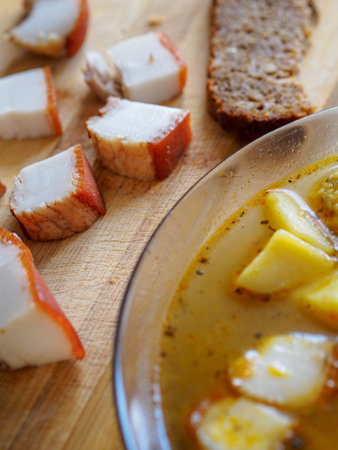 Simple food. Soup and pieces of lard lie on a wooden table. Close-up. View from aboveの写真素材