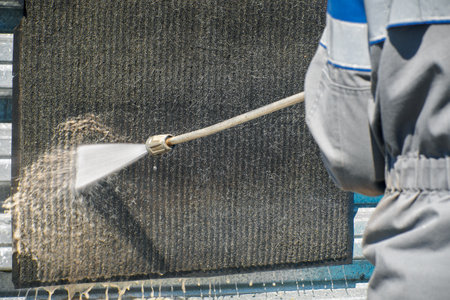 Contactless washing of rugs and carpets with a water jet under pressure. Professional clearing service for cleaning textile surfaces. Washing a dirty rug with a jet of water. Close-up.の写真素材