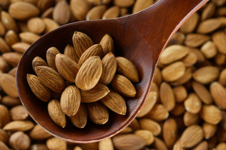 Peeled almond kernels in a wooden spoon. View from above. Healthy nut.の写真素材