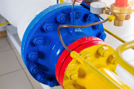 Metal bolting of pipes is painted with new yellow, red and blue paint. Part of gasification equipment. Industrial background.の写真素材