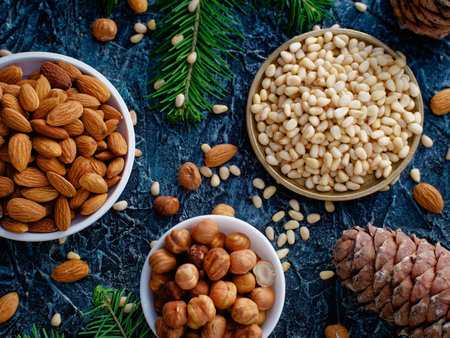 Assorted shelled nuts in bowls. Hazelnuts, almonds and pine nuts. Still life from placer of nuts. Top view. Background.の写真素材