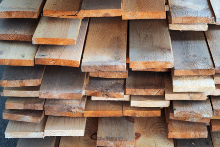 New planed wooden boards stacked in sawmill. Procurement and sale of building material. Dry wood. Woodworking. Background.の写真素材