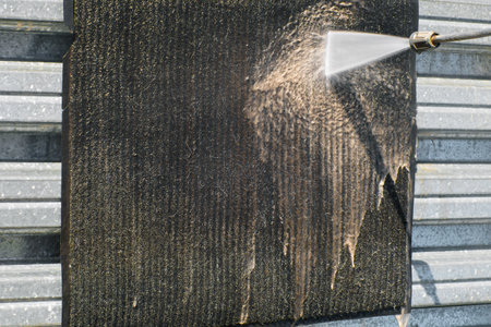 Contactless washing of rugs and carpets with a water jet under pressure. Professional clearing service for cleaning textile surfaces. Washing a dirty rug with a jet of water. Close-up.の写真素材